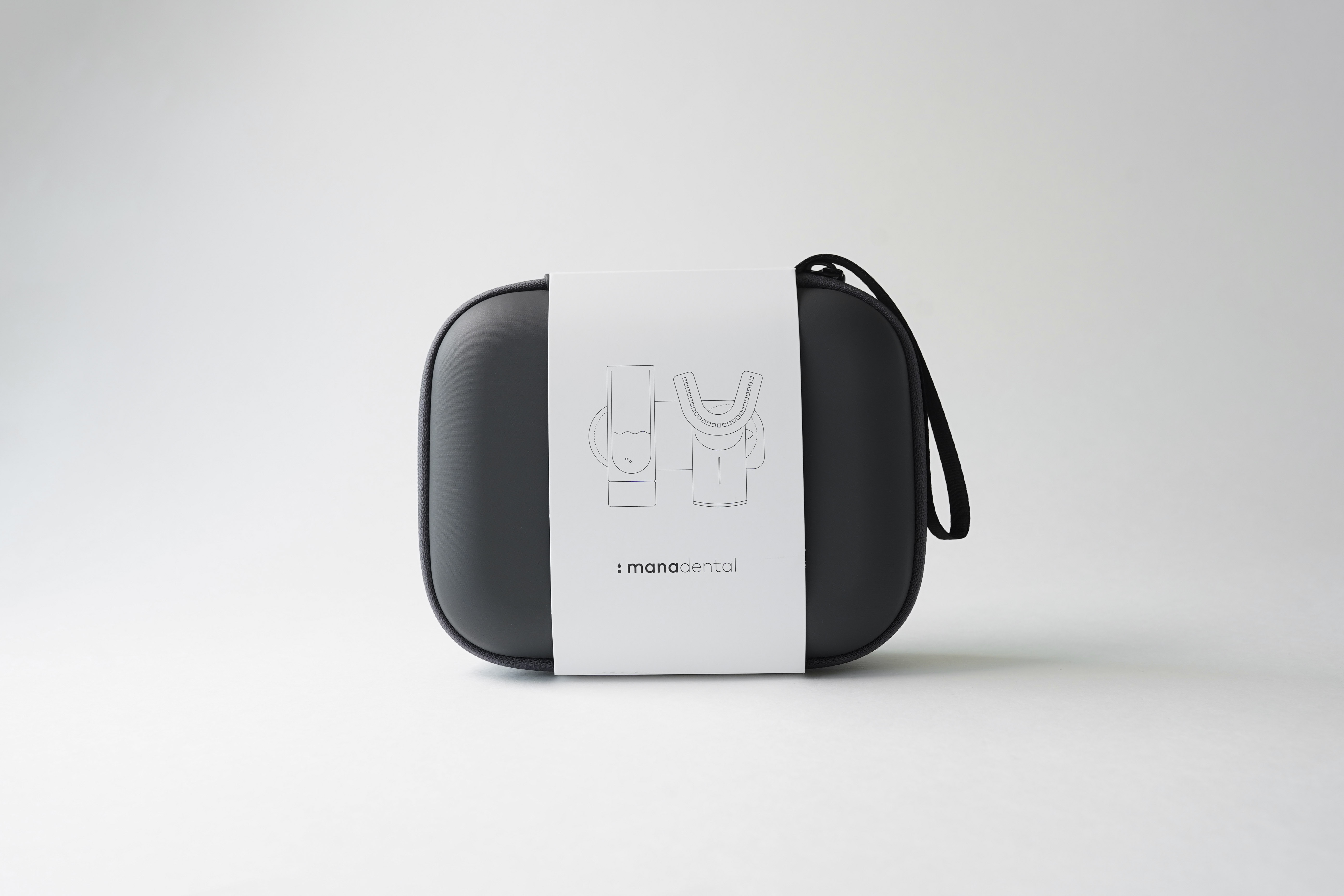 Das manadental Travel Case in anthrazit mit weißer Verpackungsbanderole vor weißem Hintergrund - Produktfoto für den manadental Online Shop